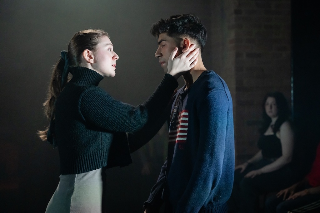 Action shot of the spring 2024 Shakespeare in Performance at RADA final presentation of Julius Caesar. Two actors stand face to face in mid-performance. The actor on the left cups the face of the actor on the right. 